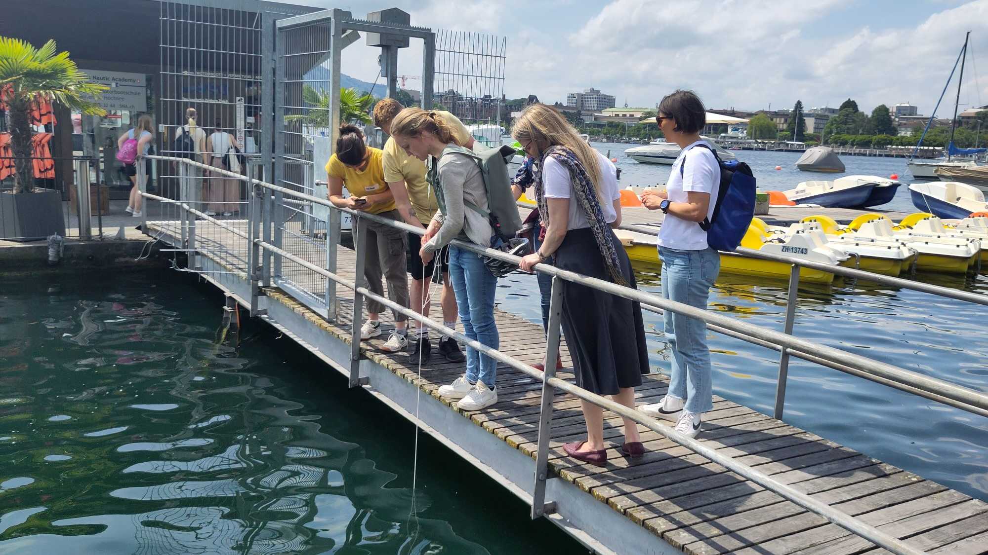 Nicole Pfefferle (Bildmitte) nimmt eine Plankton-Probe am Zürichsee im Rahmen des CAS-Kurses. 